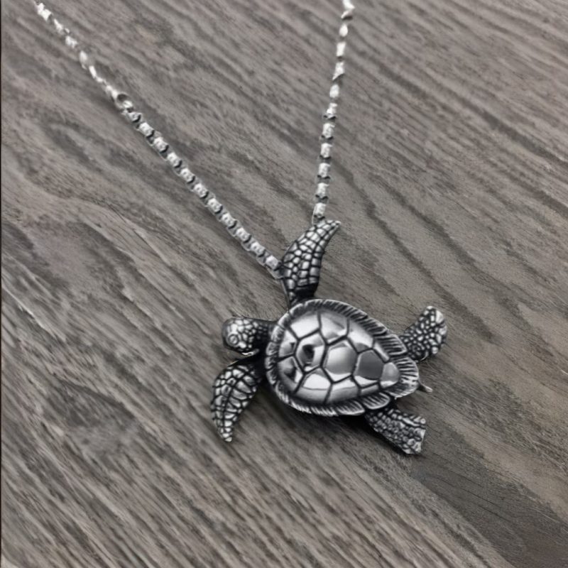 Collier homme avec pendentif tortue en métal argenté, chaîne fine et design élégant, parfait pour un style décontracté.