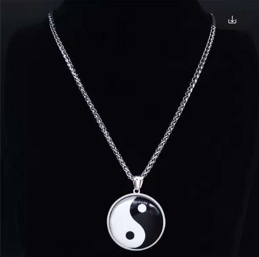 Photo d’un collier homme avec pendentif yin yang en métal noir et blanc sur chaîne argentée fine.
