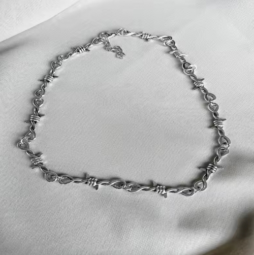 Collier barbelé pour homme en métal noir, style robuste et tendance, idéal pour un look rebelle et streetwear.